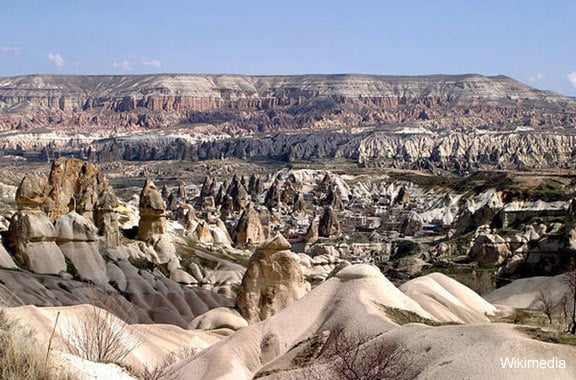 The town Göreme with rock houses in front of the spectacularly coloured valleys nearby. 