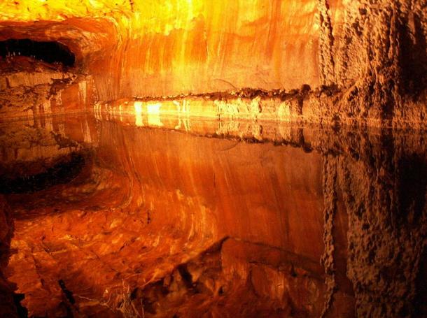 Las cámaras y las venas de la sal se reflejan en las piscinas de agua inmóvil de salmuera de la mina de sal Khewra. 