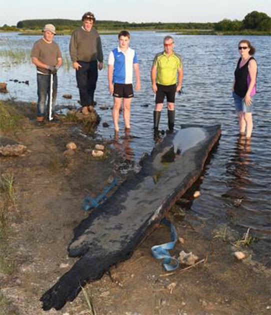 Cathal McDonagh y su familia con el bote de troncos de cinco metros que podría datarse del 2.000 a.C. (Cortesía de Mick McCormack a través de Irish Central)