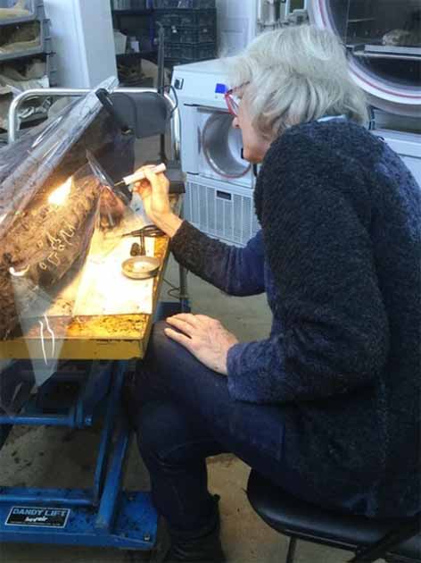 Judith Dobie, Archaeological Illustrator at Historic England, tracing the markings on the Boxford Timber. (© Historic England)