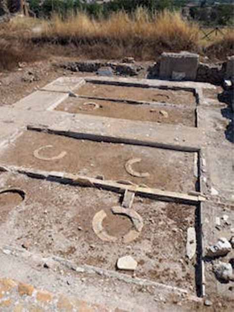 The cellar with marble-lined distribution channels and eight buried clay jars reinstated in their original positions. (E. Dodd, Author provided)