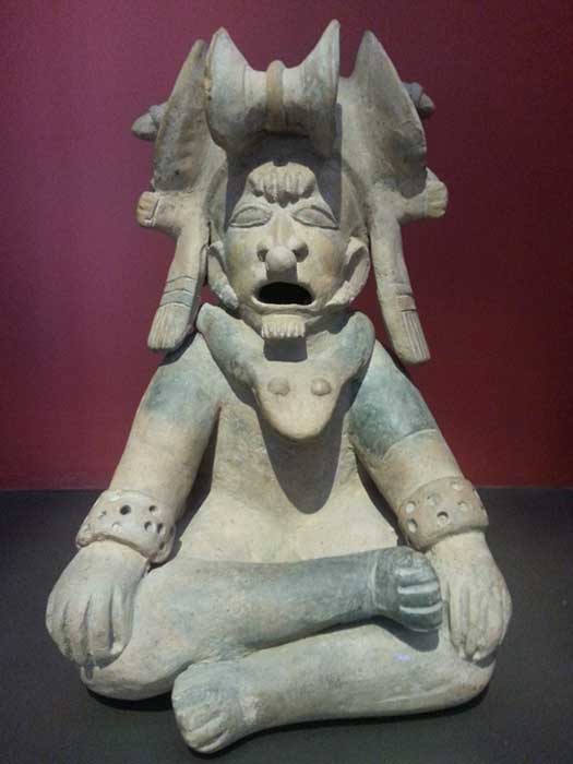 Un homme de haut rang modelé en position de lotus. Sa coiffe à grandes cornes et le collier en forme de serpent sont typiques d'un chaman de la culture de Bahia (500 av. J.-C. - 500 apr. J.-C.) en Équateur. Artefact à la Casa del Alabado : Museo de Arte Precolombino, Quito, Équateur. (Crédit : Alicia McDermott)