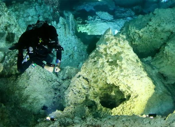 Los estudios muestran que las hogueras en el cenote Aktun Ha fueron creadas por el hombre hace más de 10,000 años. Octavio del Río frente a la hoguera principal. (Imagen: INAH)