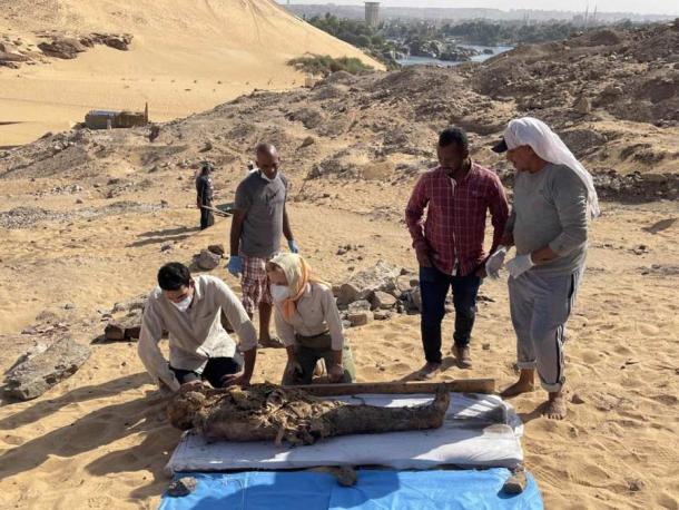 Archaeologists from the Italian-Egyptian mission examining a newly extracted mummy at the Greco-Roman tomb site in west Aswan. (Egyptian-Italian Mission (EIMAWA))