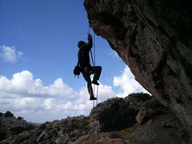   Climbing with ropes to reach the cave. (Image: Yoav Negev, courtesy of the Israel Antiquities Authority) 