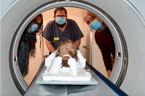 Left to right - Dana Goodburn-Brown (archaeological conservator), Tristan Barnden (Lead radiographer, Nuclear Medicine, Maidstone and Tunbridge Wells NHS Trust), and James Elliott (Canterbury Christ Church University). Centre - The mummy head, looking from underneath the chin. (James Elliot / Paleoimaging)