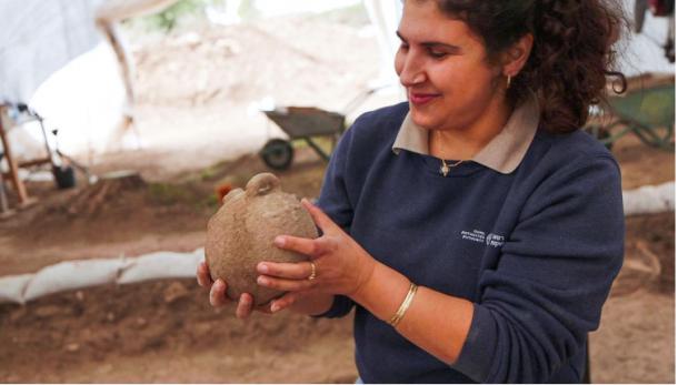 Maayan Hamed, one of the excavation manager holds a vessel. 