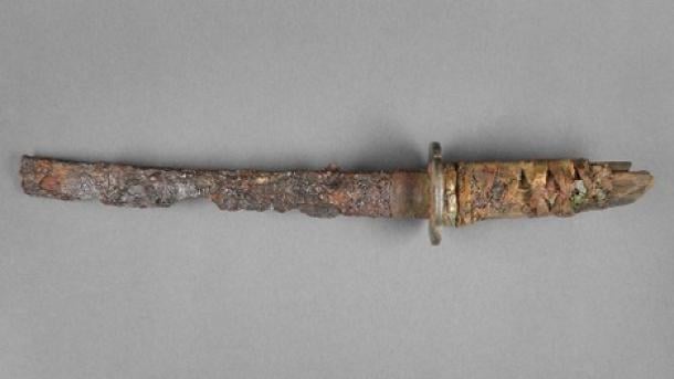 Overall view of the Wakizashi sword after restoration. The fragmented textile wrapping with parts of the ray skin and the underlying decorative element made of copper (Menuki) are clearly visible.