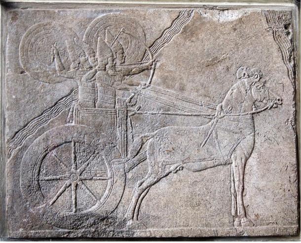 Scene from Ashurbanipal (668-627 BC) campaign against the Elamite city Hamaru, shows an Assyrian chariot with charioteer and archer protected from enemy attack by shield bearers. Assyrian relief from Nineveh. Alabaster relief, made about 650 BC.  