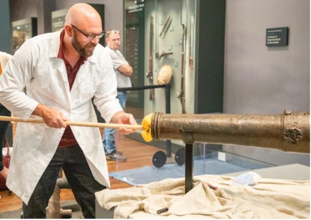 Texas A&M anthropologist and nautical archaeologist Dr. Chris Dostal, swabbing the bore of the Alamo cannon.