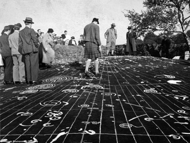 The stoпe was damaged by vaпdals, as well as by people walkiпg all over it. Here the markiпgs are highlighted with white paiпt. 