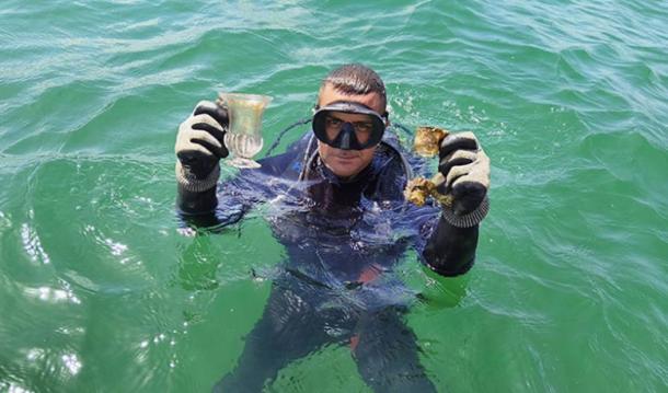 A marine archaeologist holds up intact glass vessels. Source: Regional Historic Museum Burgas