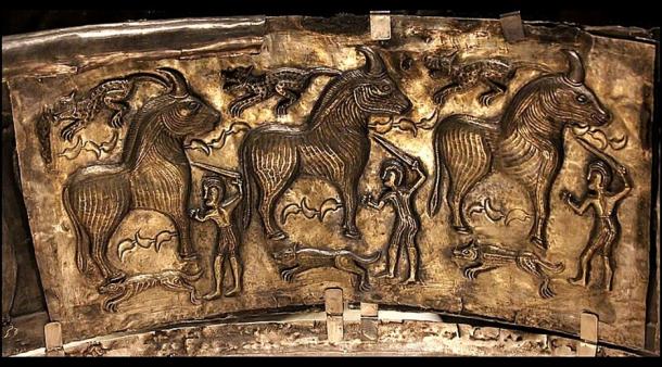 A panel from the Gundestrup Cauldron depicts three warriors sacrificing three bulls. The scene also features three hunting dogs and three felines, possibly leopards. 