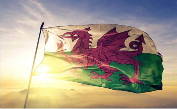 Wales Welsh flag waving on the top sunrise mist fog. Source: Oleksii/Adobe Stock