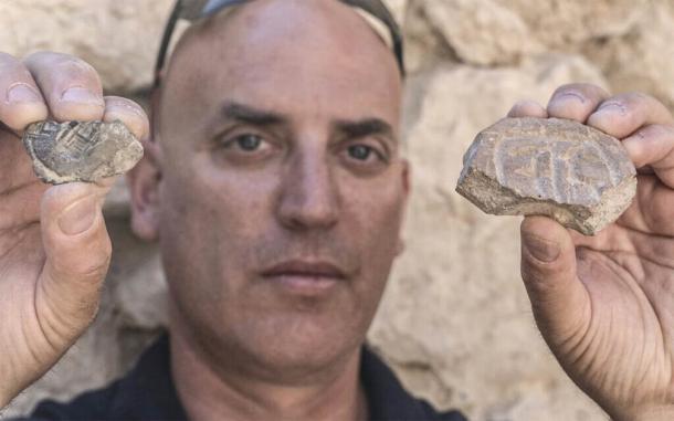 El Dr. Yiftah Shalev, de la Autoridad de Antigüedades de Israel, con el sello y la impresión del sello de la era persa, ambos descubiertos en la excavación de un estacionamiento en Jerusalén. (Shai Halevy / Autoridad de Antigüedades de Israel)