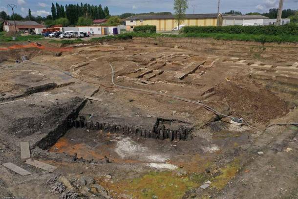 View to the northwest of the excavation site, with the canal in the foreground and the glass workshop in the background. (© Frédéric Audouit, Inrap)