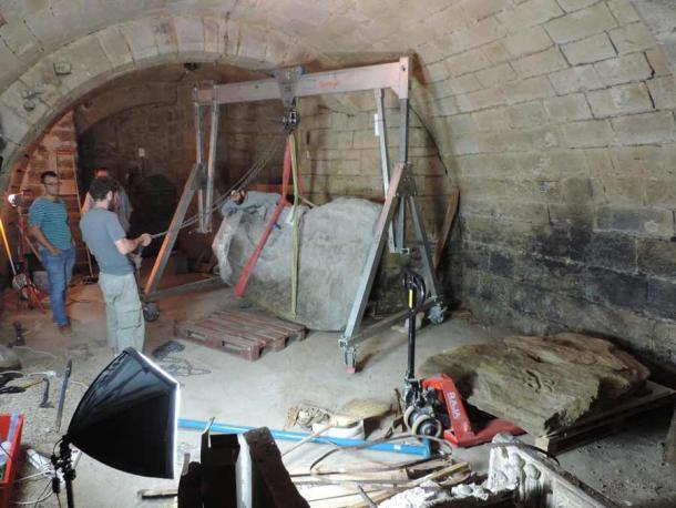 Lifting and positioning of the Bronze Age stone map that was luckily rediscovered in 2014 in the chateaux cellar. (Clément Nicolas, Yvan Pailler / Inrap)