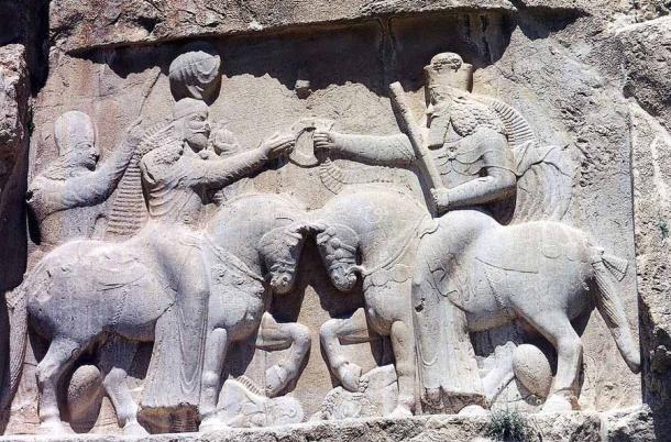 A relief at Naqsh-e Rustam in modern-day Iran showing Ardashir I and an unidentified cavalier. This Persian rock relief depicts Ardashir I's coronation scene, as the first king of the Sassanid Empire of Iran. Ardashir I receives the cydaris ring of power, the Zoroastrian symbol of kingship, from the spirit of Darius the Great of the Achaemenid dynasty. The inscription in Persian, Parthian, and Greek, reads: This is the image of the Hormizd-worshipping Majesty Ardashir, whose origin is of the gods. (Ginolerhino 2002 / CC BY-SA 3.0)