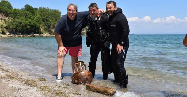 Elated researchers posing with a perfect amphorae and a worked stone found underwater, just off the coast of Cape Chiroza. (Burgas Municipality)