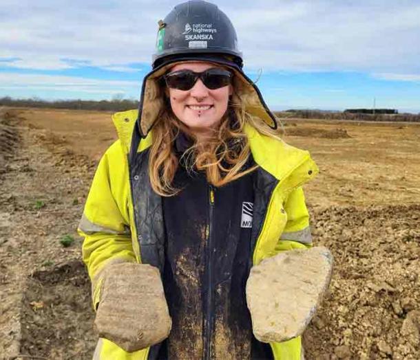 Supervisor Charlie holds two large pieces of millstone from the dig. (MOLA)